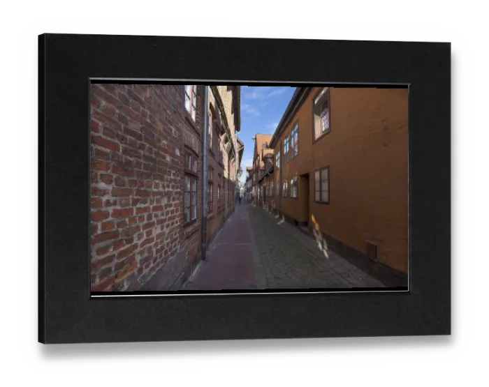 Gerahmter Druck : Historische Altstadt-Häuser in einer gepflasterten Gasse.