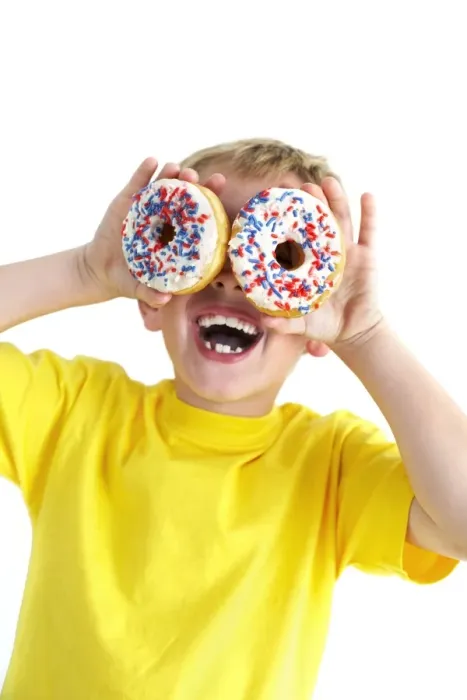 Gerahmter Druck : Junge spielt mit Donuts Gerahmter Druck : Junge spielt mit Donuts