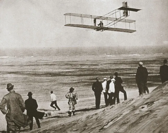 Gerahmter Druck : Die Brüder Wright testen ein frühes Flugzeug in Kitty Hawk, Nordkarolina (USA), ca. 1903 Gerahmter Druck : Die Brüder Wright testen ein frühes Flugzeug in Kitty Hawk, Nordkarolina (USA), ca. 1903