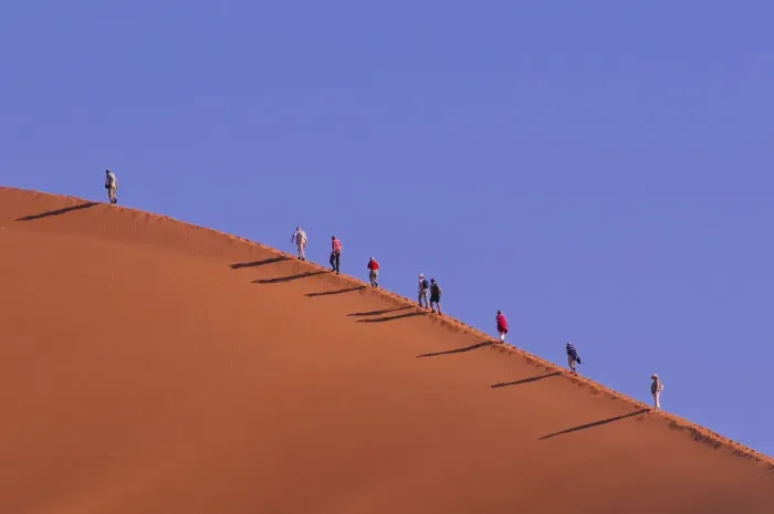 Gerahmter Druck : Desert. Menschen wandern auf dem großen Vater Sanddunen in der Nähe von Gerahmter Druck : Desert. Menschen wandern auf dem großen Vater Sanddunen in der Nähe von