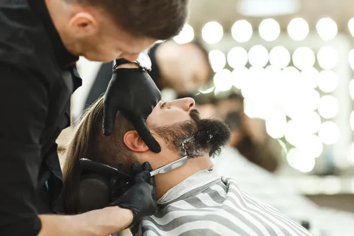 Gerahmter Druck : Friseur schneidet Bartform für Mann. Gerahmter Druck : Friseur schneidet Bartform für Mann.