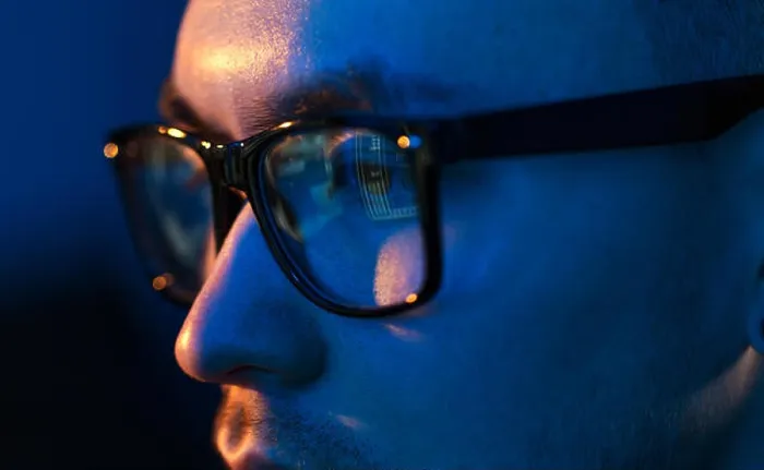 Gerahmter Druck : Nahaufnahme eines Hackers in Brille, der auf Bildschirm schaut. Gerahmter Druck : Nahaufnahme eines Hackers in Brille, der auf Bildschirm schaut.