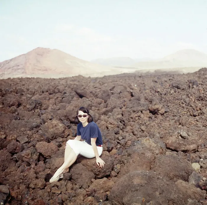 Gerahmter Druck : Lanzarote. Eine junge Frau sitzt in den Lavafeldern der Montanas del Fuego