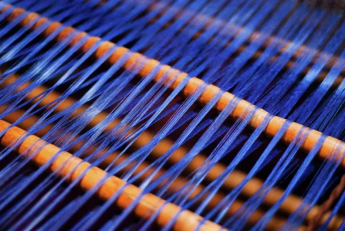 Gerahmter Druck : Ein Detail eines blauen Fadens, der an einem Webstuhl gewebt wird. Gerahmter Druck : Ein Detail eines blauen Fadens, der an einem Webstuhl gewebt wird.