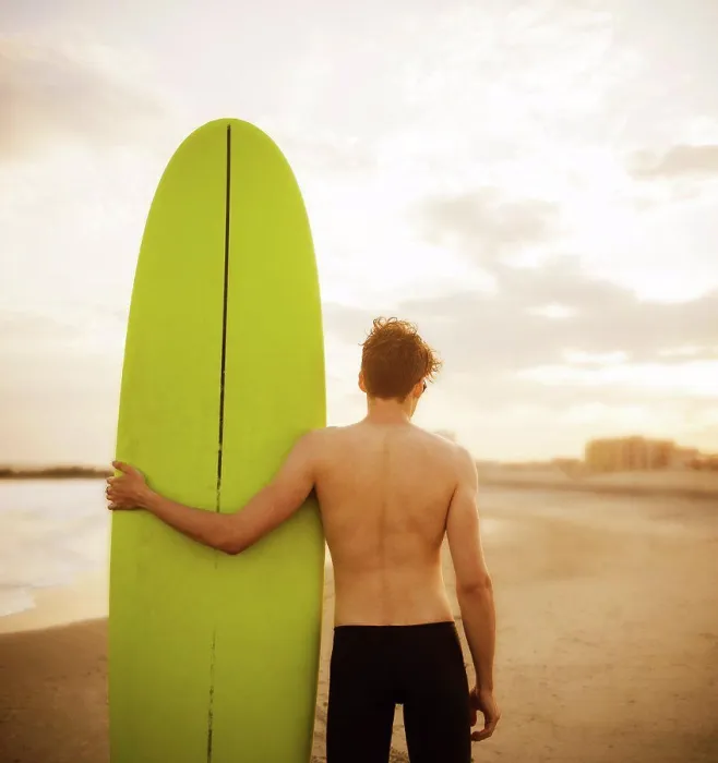 Gerahmter Druck : Jüngerer Mann mit einem Surfbrett. Gerahmter Druck : Jüngerer Mann mit einem Surfbrett.