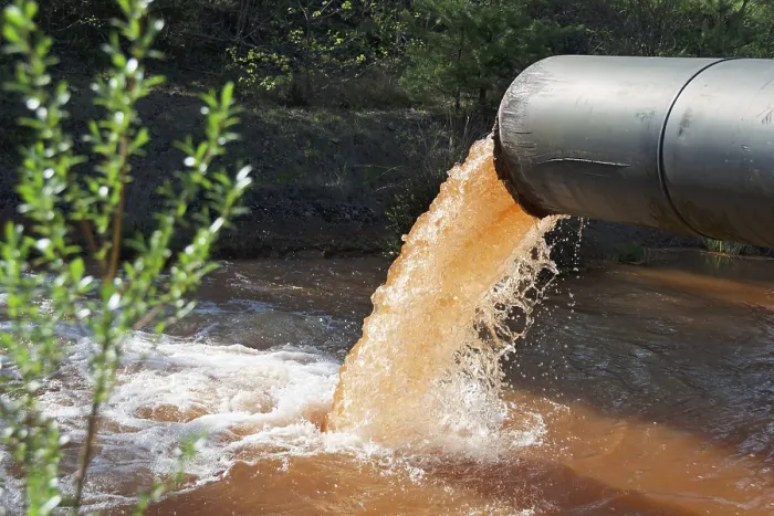 Gerahmter Druck : Abwasser wird in den Fluss eingeleitet. Gerahmter Druck : Abwasser wird in den Fluss eingeleitet.