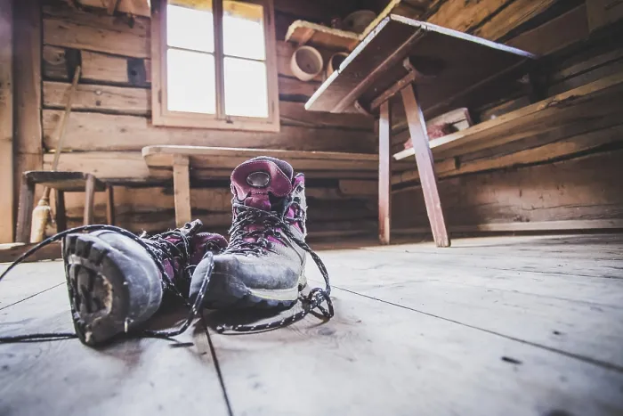 Gerahmter Druck : Alpine Stiefel in einem rustikalen Bergchalet.
