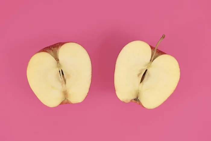 Gerahmter Druck : Apfel halbiert auf rosa Hintergrund