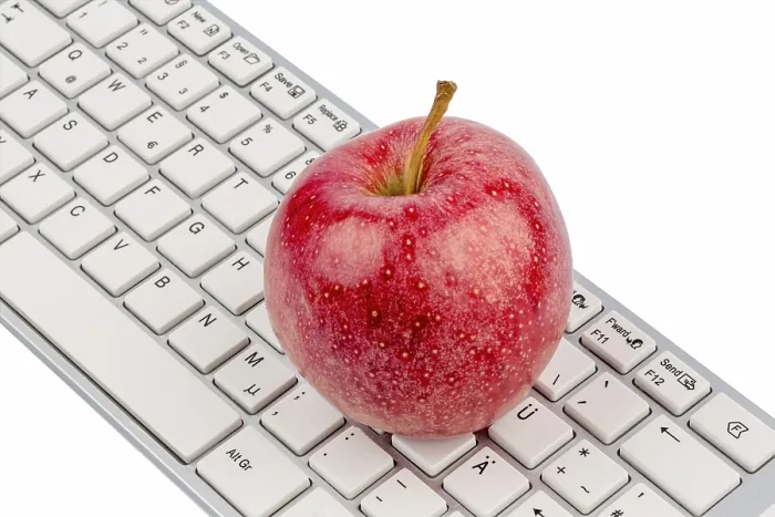 Gerahmter Druck : Ein Apfel liegt auf der Tastatur eines Computers. Gerahmter Druck : Ein Apfel liegt auf der Tastatur eines Computers.