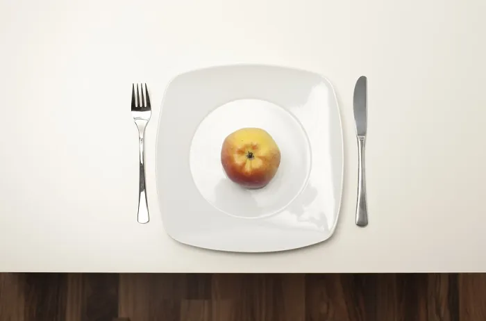 Gerahmter Druck : Ein Apfel auf einem weißen Teller. Gerahmter Druck : Ein Apfel auf einem weißen Teller.
