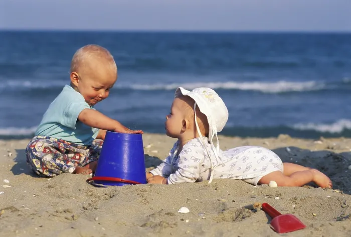 Gerahmter Druck : Zwei Babys spielen am Strand. Gerahmter Druck : Zwei Babys spielen am Strand.