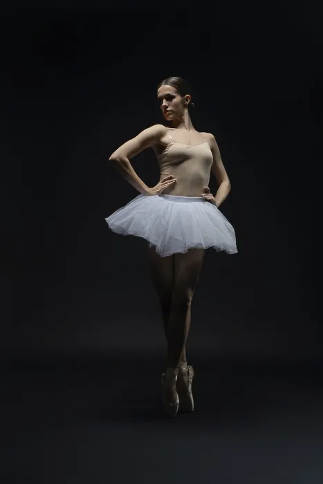 Gerahmter Druck : Ein Balletttänzer zeigt Eleganz in einem dunklen Studio. Gerahmter Druck : Ein Balletttänzer zeigt Eleganz in einem dunklen Studio.