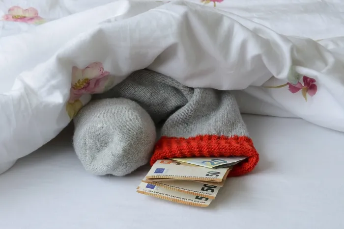 Gerahmter Druck : Banknoten in Strumpf unter Daunendecke