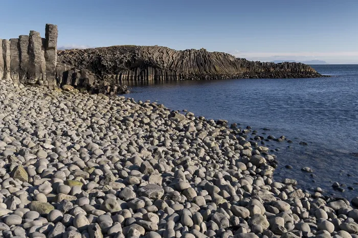 Gerahmter Druck : Basaltklippe und Strand mit gerundeten Steinen. Gerahmter Druck : Basaltklippe und Strand mit gerundeten Steinen.