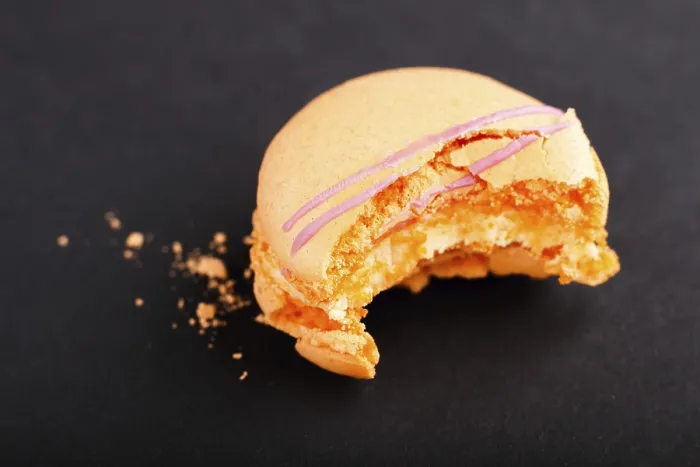 Gerahmter Druck : Bitten orange Macaron oder Macaroon-Torte auf schwarzem Hintergrund Gerahmter Druck : Bitten orange Macaron oder Macaroon-Torte auf schwarzem Hintergrund