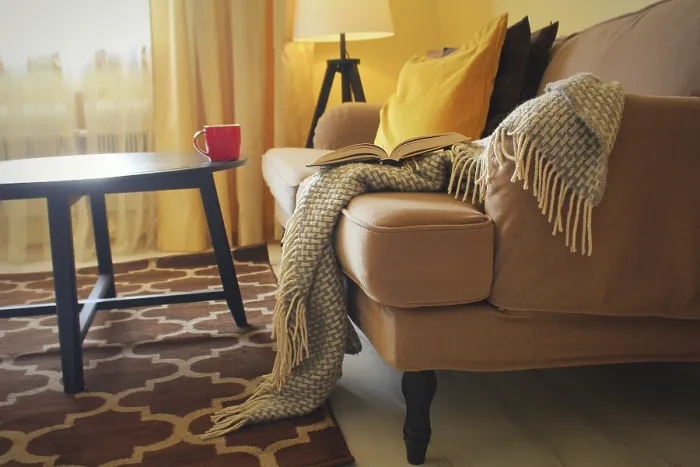 Gerahmter Druck : Buch, Tasse und warmes Plaid auf Sofa. Gerahmter Druck : Buch, Tasse und warmes Plaid auf Sofa.