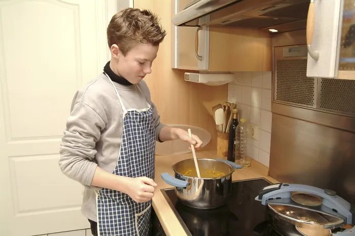 Gerahmter Druck : Junge kocht. Gerahmter Druck : Junge kocht.