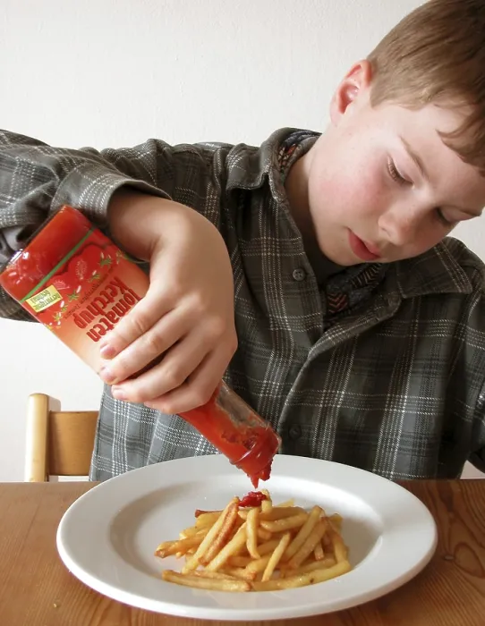 Gerahmter Druck : Junge isst Chips. Gerahmter Druck : Junge isst Chips.