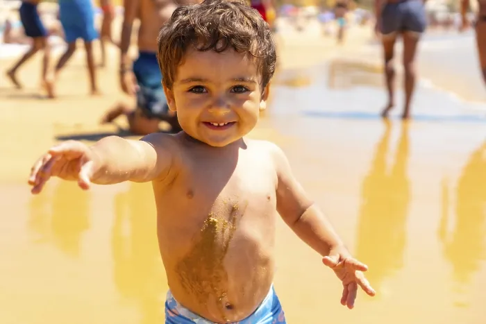 Gerahmter Druck : Ein Junge spielt im Sand und hat Spaß.
