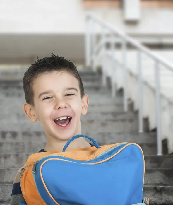 Gerahmter Druck : Junge mit Schulrucksack vor der Schule.