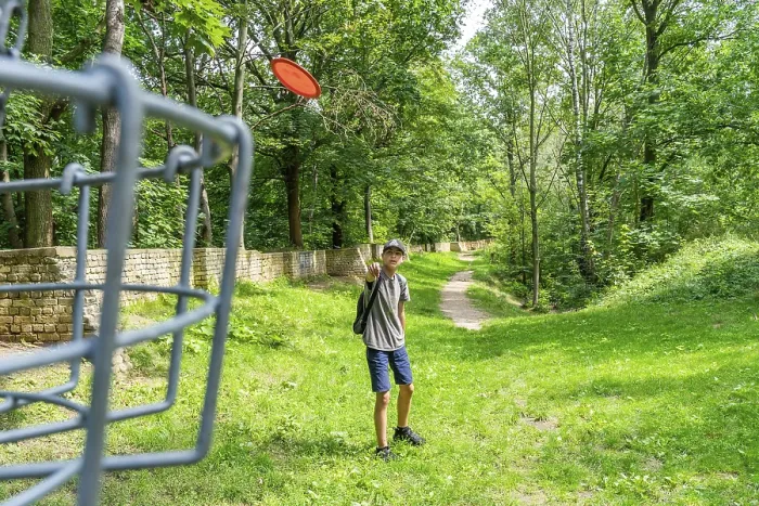 Gerahmter Druck : Ein Junge wirft einen Disc auf einem Discgolfplatz. Gerahmter Druck : Ein Junge wirft einen Disc auf einem Discgolfplatz.