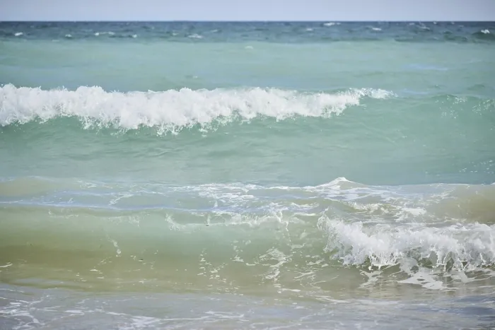 Gerahmter Druck : Wellen, die auf einem sandigen Strand brechen. Gerahmter Druck : Wellen, die auf einem sandigen Strand brechen.