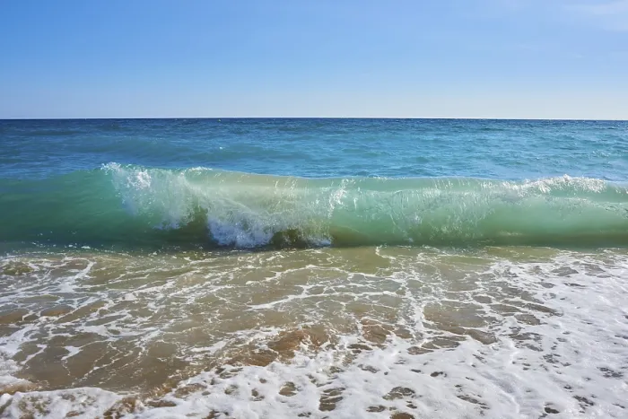 Gerahmter Druck : Wellen, die auf einem sandigen Strand brechen. Gerahmter Druck : Wellen, die auf einem sandigen Strand brechen.