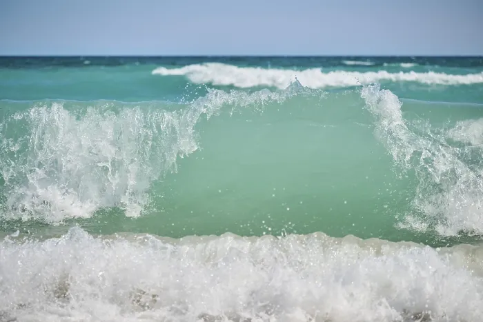 Gerahmter Druck : Wellenbrecher auf einem sandigen Strand.