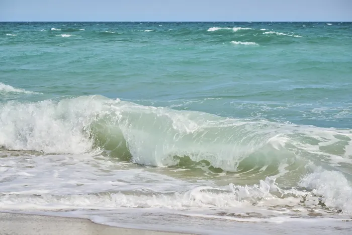 Gerahmter Druck : Wellen, die auf einem sandigen Strand brechen. Gerahmter Druck : Wellen, die auf einem sandigen Strand brechen.