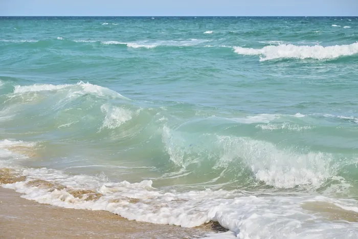 Gerahmter Druck : Wellen brechen sich an einem sandigen Strand. Gerahmter Druck : Wellen brechen sich an einem sandigen Strand.