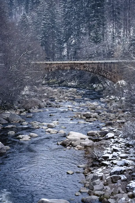 Gerahmter Druck : Brücke über einen steinigen Fluss im Winter mit Schnee. Gerahmter Druck : Brücke über einen steinigen Fluss im Winter mit Schnee.