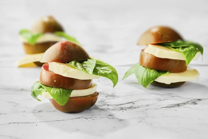 Gerahmter Druck : Braunes Schokoladen-Tomaten, Mozzarella und Basilikum geschnitten auf Scheiben und gestapelt auf einem Marmorhintergrund (selective focus Foto). Gerahmter Druck : Braunes Schokoladen-Tomaten, Mozzarella und Basilikum geschnitten auf Scheiben und gestapelt auf einem Marmorhintergrund (selective focus Foto).