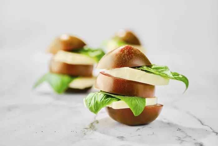 Gerahmter Druck : Braunes Schokoladen-Tomaten, Mozzarella und Basilikum auf Scheiben geschnitten und auf Marmorhintergrund gestapelt (selektiver Fokus-Foto). Gerahmter Druck : Braunes Schokoladen-Tomaten, Mozzarella und Basilikum auf Scheiben geschnitten und auf Marmorhintergrund gestapelt (selektiver Fokus-Foto).