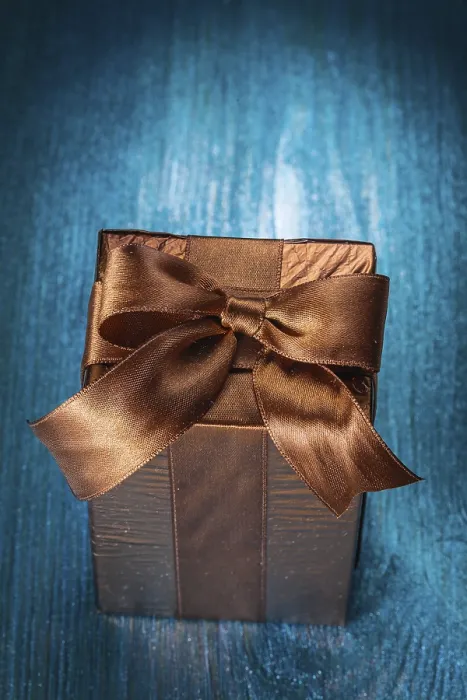 Gerahmter Druck : Braunes Geschenkbox auf blauer Tafel. Gerahmter Druck : Braunes Geschenkbox auf blauer Tafel.