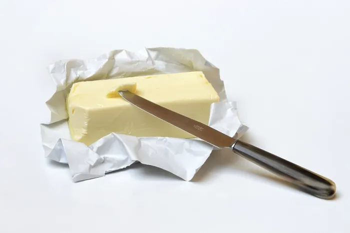 Gerahmter Druck : Butter mit geöffnetem Paket und Messer. Gerahmter Druck : Butter mit geöffnetem Paket und Messer.