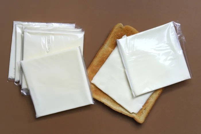 Gerahmter Druck : Käseplatten mit Toast, verarbeiteter Käse in Verpackung. Gerahmter Druck : Käseplatten mit Toast, verarbeiteter Käse in Verpackung.