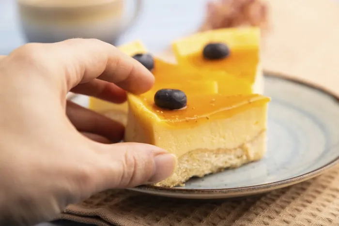 Gerahmter Druck : Käsekuchen mit Mangocreme in der Hand. Gerahmter Druck : Käsekuchen mit Mangocreme in der Hand.