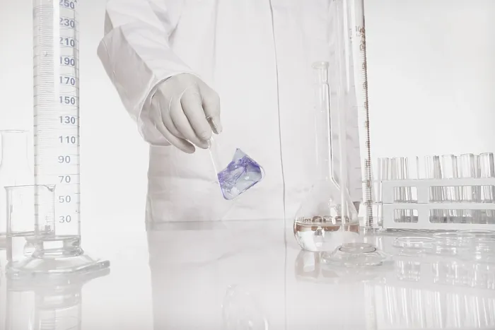 Gerahmter Druck : Chemiker überprüft Flüssigkeit in einem Flasche in einem Labor. Gerahmter Druck : Chemiker überprüft Flüssigkeit in einem Flasche in einem Labor.