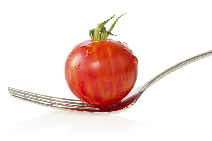 Gerahmter Druck : Tomate aus der Cherry-Sorte auf einer Gabel. Isoliert auf weißem Hintergrund.