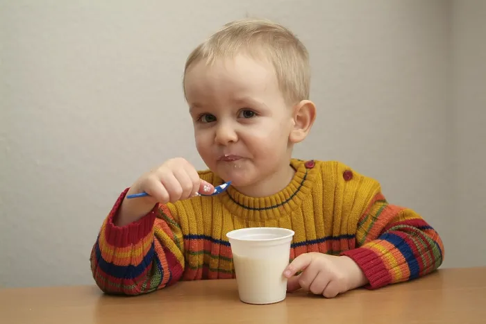 Gerahmter Druck : Das Kind isst Joghurt. Gerahmter Druck : Das Kind isst Joghurt.