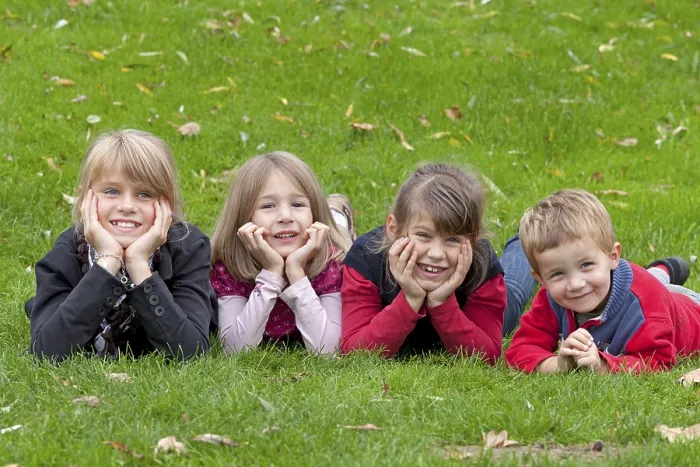 Gerahmter Druck : Vier Kinder liegen auf einem Wiesen. Gerahmter Druck : Vier Kinder liegen auf einem Wiesen.