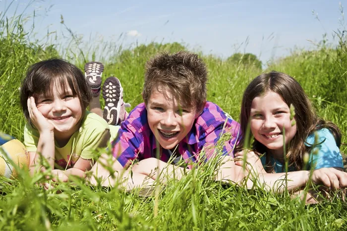 Gerahmter Druck : Drei Kinder liegen in einer Wiese. Gerahmter Druck : Drei Kinder liegen in einer Wiese.