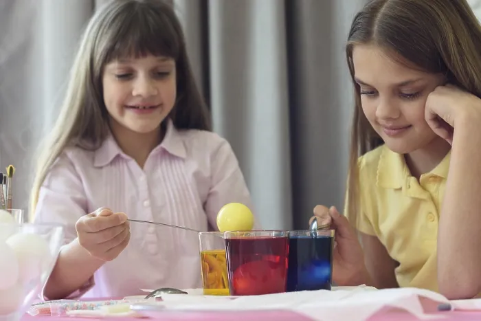 Gerahmter Druck : Kinder färben Ostereier in Gläsern mit flüssiger Farbe. Gerahmter Druck : Kinder färben Ostereier in Gläsern mit flüssiger Farbe.