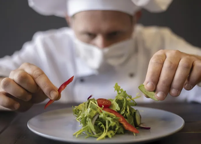 Gerahmter Druck : Nah dran: Chef mit Maske bereitet Gericht. Gerahmter Druck : Nah dran: Chef mit Maske bereitet Gericht.
