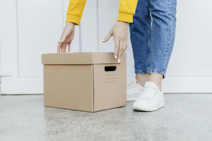 Gerahmter Druck : Hände, die eine Schachtel heben. Gerahmter Druck : Hände, die eine Schachtel heben.
