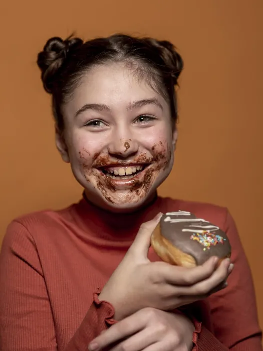 Gerahmter Druck : Nah dran: Ein Kind hält einen Doughnut. Gerahmter Druck : Nah dran: Ein Kind hält einen Doughnut.