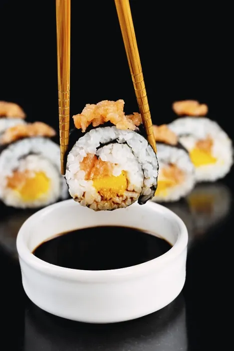 Gerahmter Druck : Nahaufnahme eines Sushi-Rolls mit Lachs und Mango. Gerahmter Druck : Nahaufnahme eines Sushi-Rolls mit Lachs und Mango.