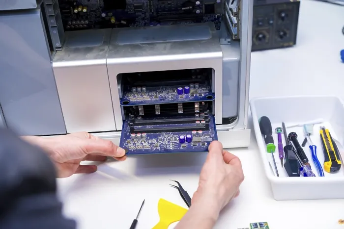 Gerahmter Druck : Enge Aufnahme der Hände eines Technikers, der ein Bauteil einer Computerarbeitsplatte in einem Werkstatt repariert. Gerahmter Druck : Enge Aufnahme der Hände eines Technikers, der ein Bauteil einer Computerarbeitsplatte in einem Werkstatt repariert.