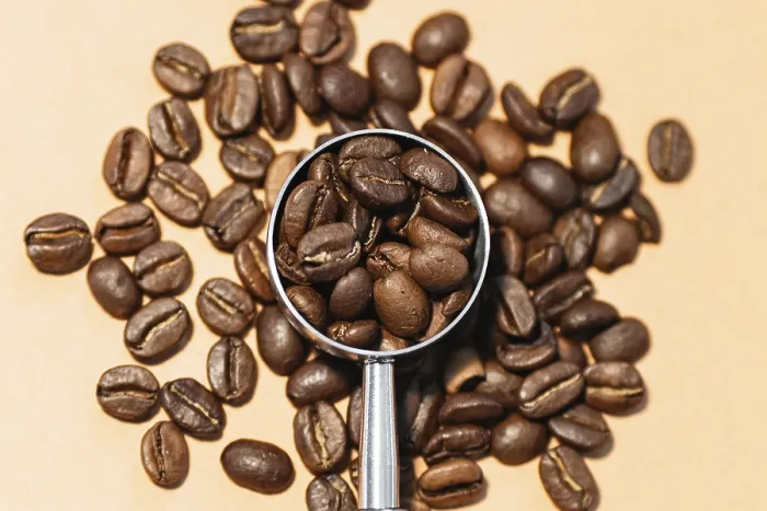 Gerahmter Druck : Ein genauer Blick auf geröstete Kaffeebohnen, die auf einer Oberfläche verstreut sind.