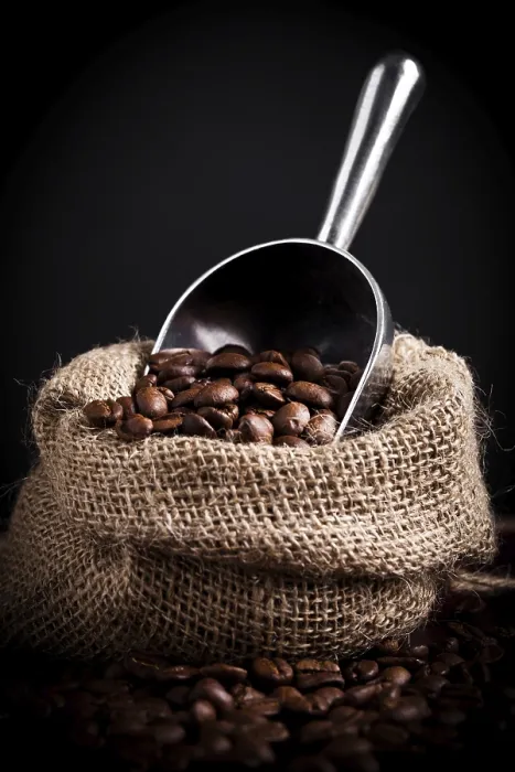 Gerahmter Druck : Kaffeebohnen aus einem Jutesack rieseln heraus. Gerahmter Druck : Kaffeebohnen aus einem Jutesack rieseln heraus.
